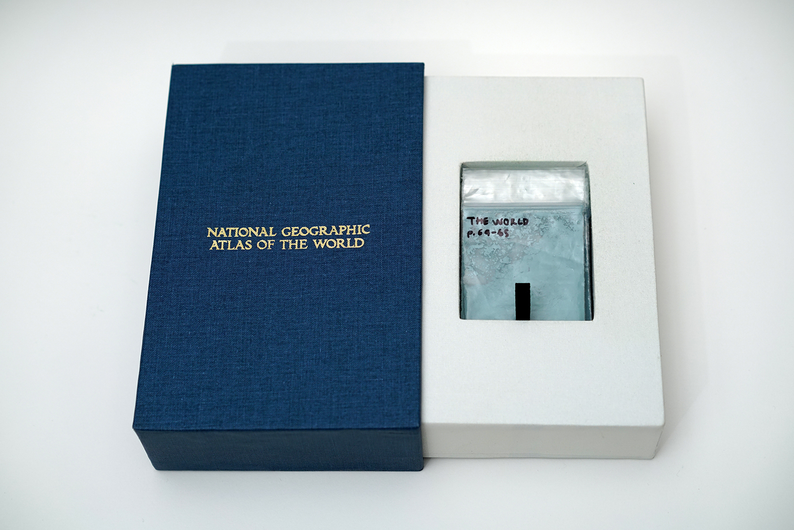 book slipcase embossed with national geographic atlas of the world containing sachets of pigments