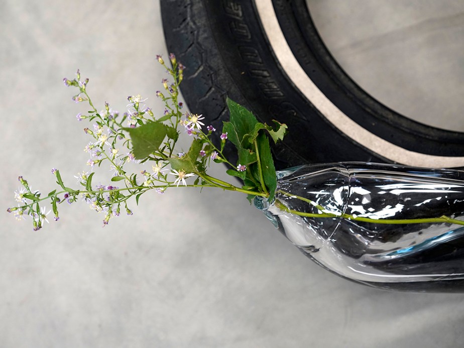 Blown glass sculpture with plant on tire