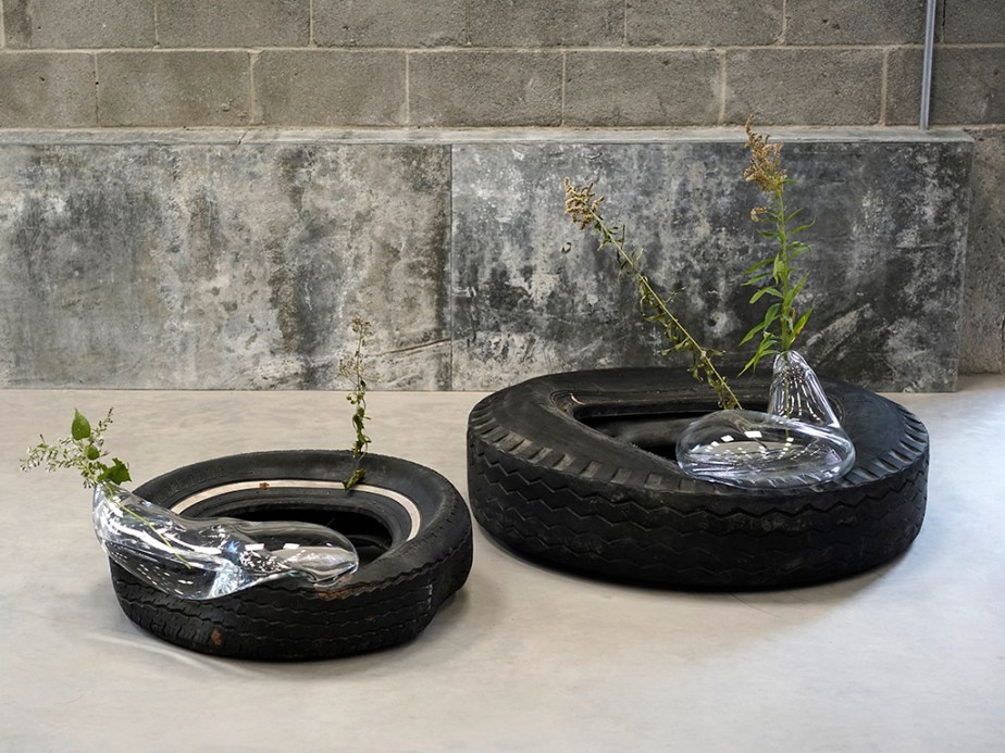Blown glass sculpture with plant on tire