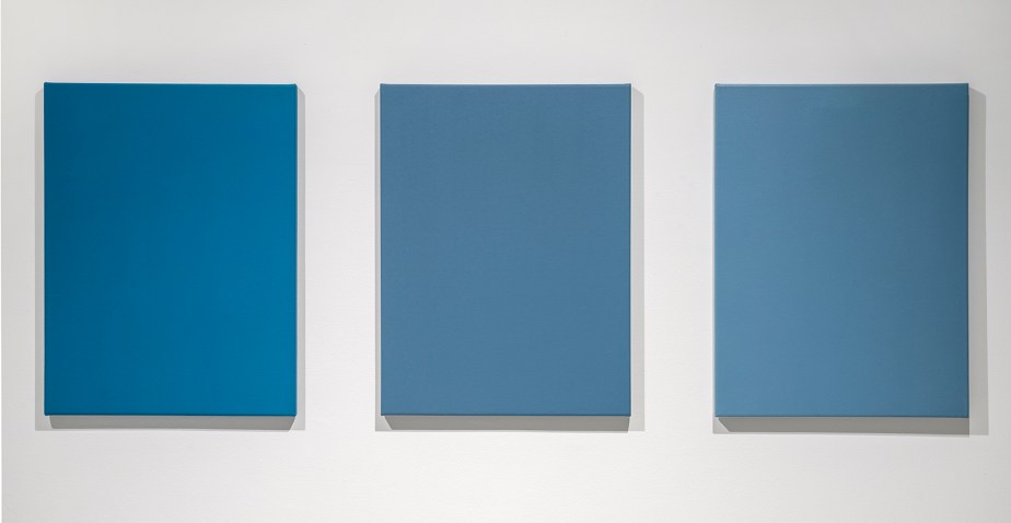 three monochrome blue paintings