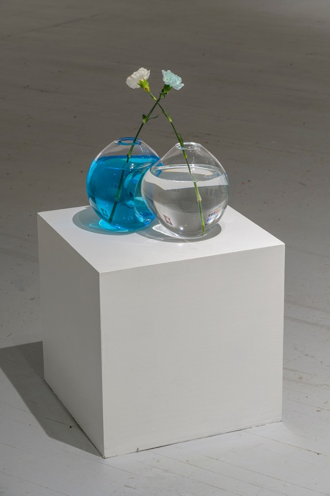 blown glass sculpture with flowers and blue pigments on a plinth